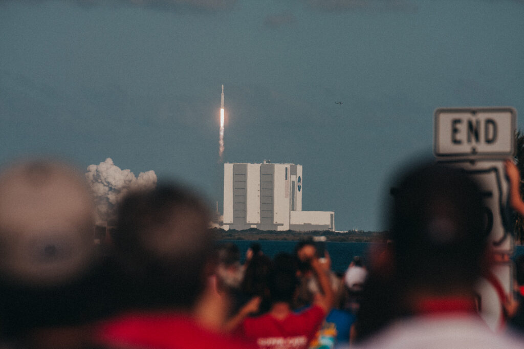 Falcon Heavy first launch with Vehicle Assembly Building and crowd in foreground